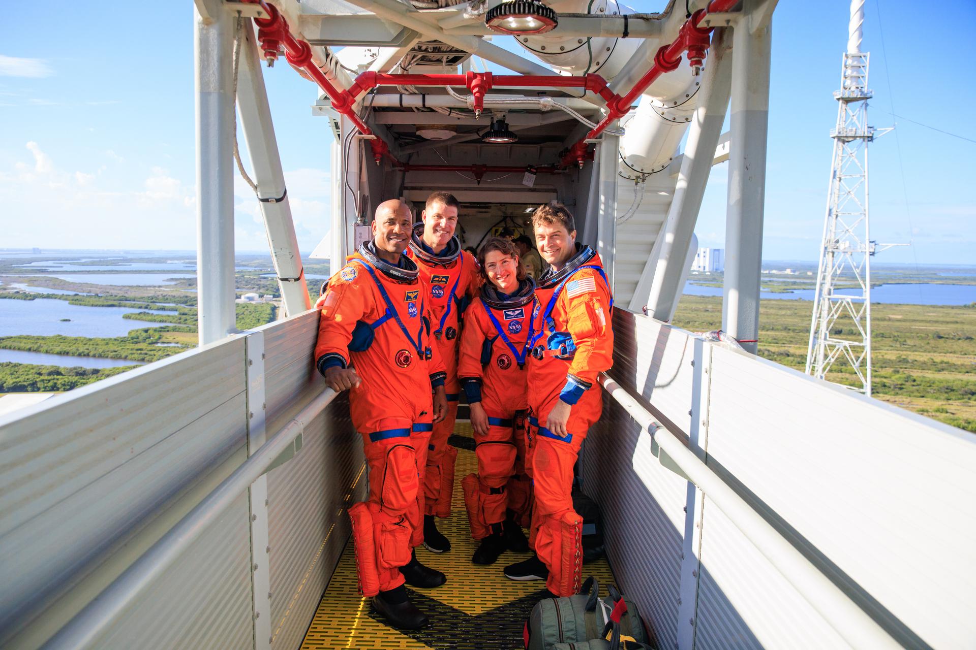 Four astronauts posing together in a modern facility